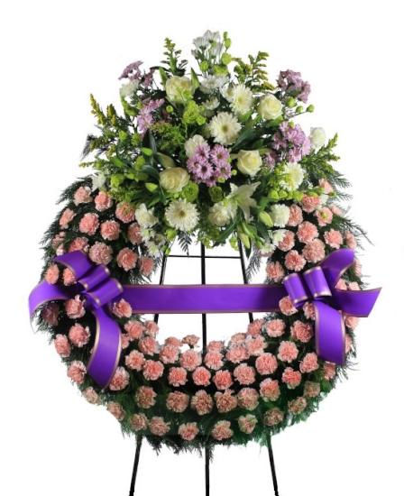 Corona funeraria claveles rosados con cabezal de flores variadas